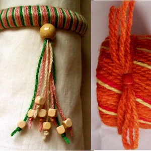 Könnte beinhalten: Zwei handgefertigte Serviettenringe. Einer ist mit rosa, grüner und weißer Wolle umwickelt, mit einer Holzperle und Quaste. Der andere ist orange mit roten und gelben Streifen und einer Quaste.