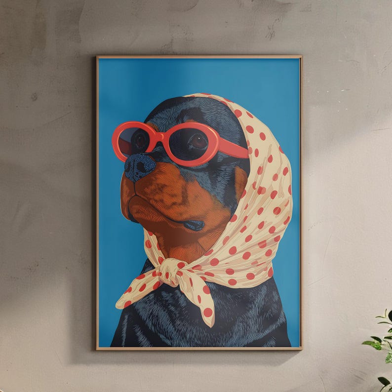 Puede incluir: Una impresi&oacute;n art&iacute;stica enmarcada que presenta un perro Rottweiler con gafas de sol rojas y un pa&ntilde;uelo crema con lunares rojos. El perro est&aacute; sobre un fondo azul brillante. La obra de arte est&aacute; en orientaci&oacute;n vertical.