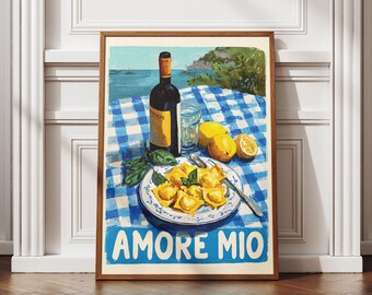 Può includere: Una stampa incorniciata con una natura morta italiana. Una bottiglia di vino, un bicchiere d'acqua, limoni e un piatto di ravioli sono disposti su una tovaglia a scacchi blu e bianca. Le parole "AMORE MIO" sono in basso.