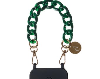 Può includere: Una custodia per smartphone nera con un cinturino a catena in acrilico verde scuro traslucido. Il cinturino è fissato alla custodia con moschettoni in metallo dorato e include un piccolo ciondolo circolare dorato con la lettera A.