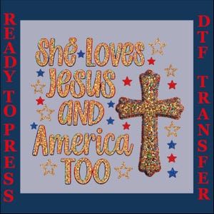 May include: A DTF transfer design featuring the gold glitter text She Loves Jesus And America Too, accompanied by a gold glitter cross and scattered red, white, and blue stars. The text Ready To Press DTF Transfer is printed vertically on the sides.