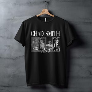 May include: Black t-shirt with a white print of Chad Smith's name and a photo of him drumming.