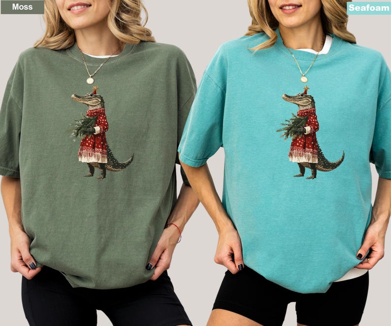 Pu&ograve; includere: Due magliette oversize, una verde muschio e una blu acqua marina, con un'illustrazione stravagante. La grafica raffigura un alligatore con un cappotto rosso fantasia e che tiene del verde. Le magliette hanno maniche corte e una vestibilit&agrave; rilassata.