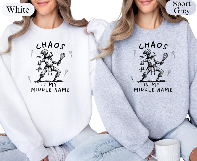 May include: White and sport grey sweatshirts with the text "Chaos is my middle name." The graphic features a frog chef holding a whisk and wearing a chef's hat. The sweatshirts are a crew neck style.