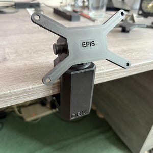 May include: A grey monitor mount with a cross-shaped top and a black clamp. The top has the text "EFIS" and the clamp has the text "DRK."