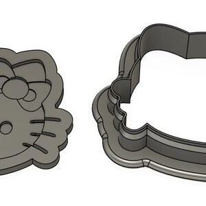 May include: Two metal cookie cutters, one shaped like Hello Kitty's face and the other a simple oval.