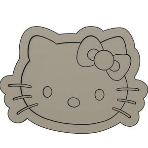 May include: A gray cookie cutter shaped like a cartoon cat with a bow. The cat has large eyes, a small nose, and a wide mouth.