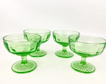 May include: Set of four green glass dessert cups with a fluted design. The cups have a pedestal base and are perfect for serving ice cream, pudding, or other desserts.