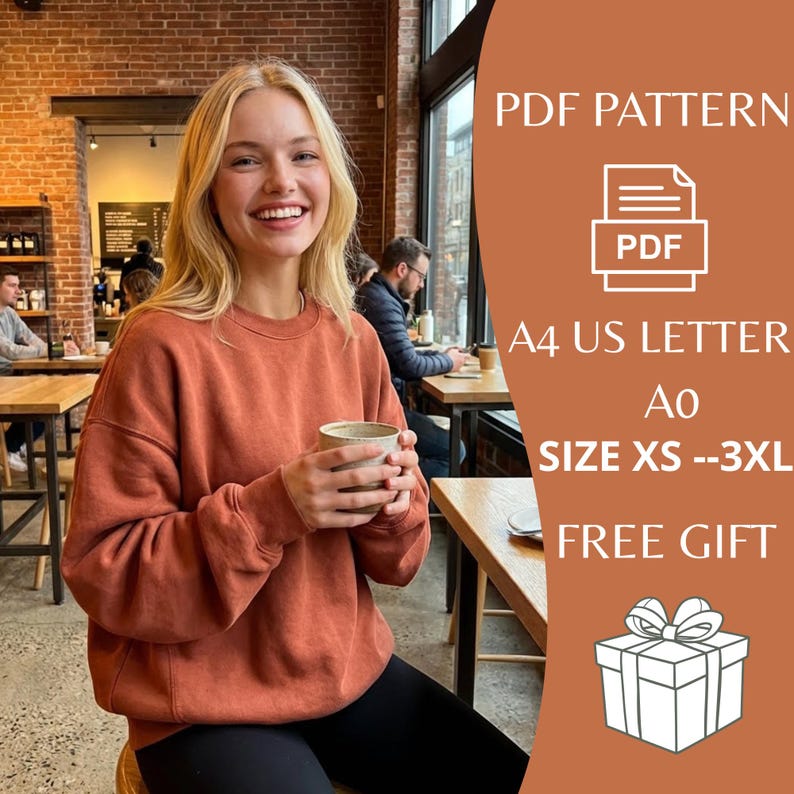 May include: A person wearing a rust-colored sweatshirt, holding a mug. The image includes text that says "PDF PATTERN", "A4 US LETTER", "SIZE XS --3XL", and "FREE GIFT". The person is sitting in a cafe.