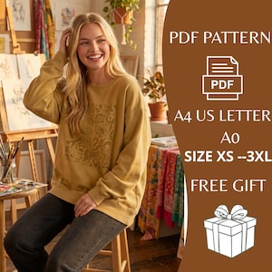 May include: Mustard-colored sweatshirt with a beige abstract design. The text on the image reads "PDF PATTERN", "A4 US LETTER", "Ao", "SIZE XS --3XL", and "FREE GIFT". The sweatshirt is worn with dark gray jeans.
