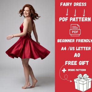 May include: A deep red satin dress with a flared skirt, thin straps, and a lace-up back design. The image includes text: FAIRY DRESS PDF PATTERN, BEGINNER FRIENDLY, A4 /US LETTER, A0, FREE GIFT + INSIDE PATTERN, and a graphic of a gift box.