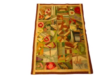 Kleiner Patchwork Quilt in Braun- und Pastelltönen.