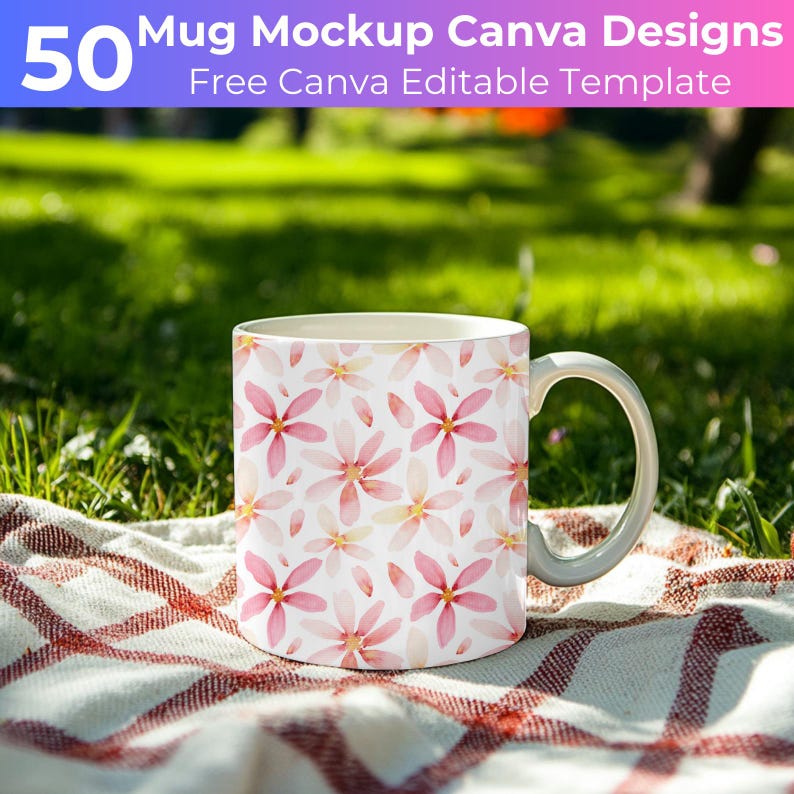 May include: White ceramic mug with a pink floral pattern on a white and red checkered blanket. The mug is sitting on a green grassy surface.