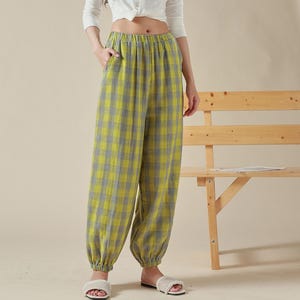 May include: Yellow and gray plaid pants with an elastic waistband and cuffed legs. The pants are loose fitting and have a casual style.