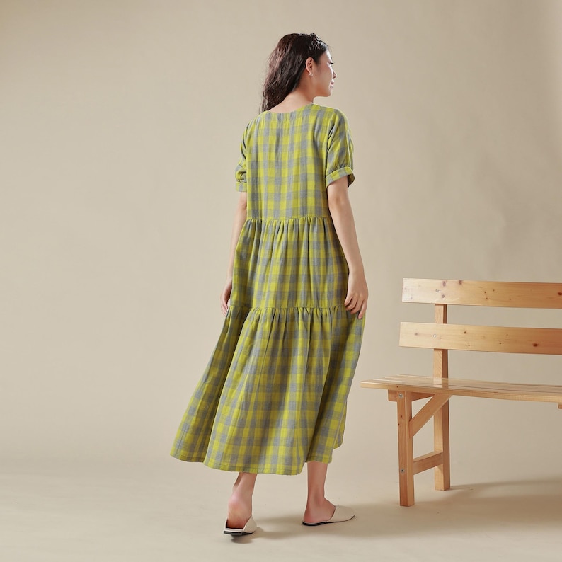 May include: A yellow and blue plaid tiered maxi dress with short sleeves. The dress is made of a lightweight fabric and has a relaxed fit.