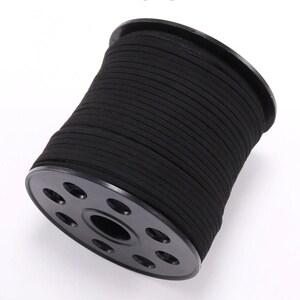 May include: A spool of black suede cord, wound tightly on a black plastic spool with a center hole and eight evenly spaced holes around the edge.