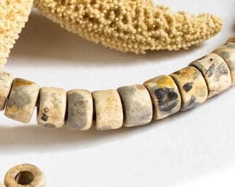 May include: A beige and brown necklace made of round ceramic beads with a starfish and leather cord. The beads have a speckled pattern.