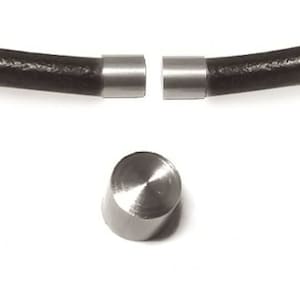 Puede incluir: Cierre magnético plateado para pulseras o collares de cuero. El cierre está hecho de dos piezas que encajan a presión y tiene un acabado liso y pulido.