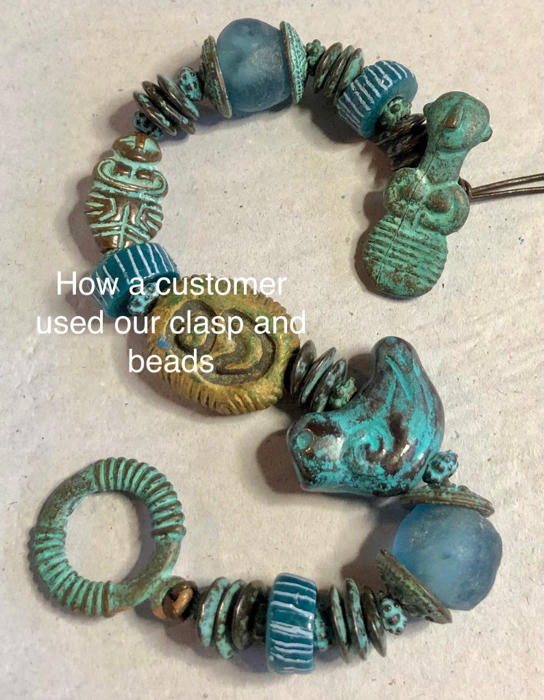 May include: A turquoise and gold bracelet with a variety of beads, including a ring clasp, a turquoise bird bead, and a glass bead. The bracelet is made with a mix of metal and glass beads.