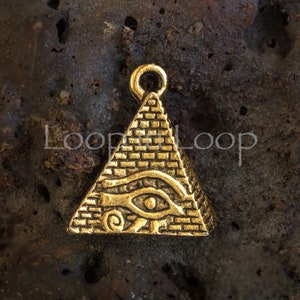 May include: A gold-colored pyramid pendant with an eye symbol, featuring a loop at the top for hanging. The pyramid is detailed with brick-like textures and the eye symbol is in the center. The text "Loop Loop" is on the left and right side of the pendant.