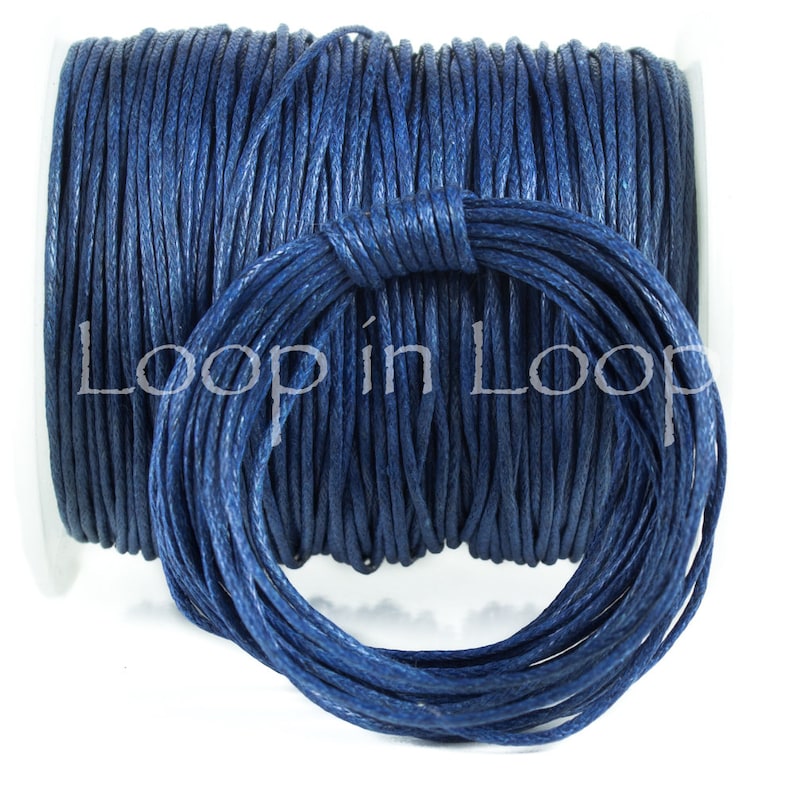 May include: A spool of dark blue cord wrapped in a tight coil, with a smaller circular bundle of the same dark blue cord positioned in front. The text Loop in Loop is overlaid across the center of the image in a light gray font color.