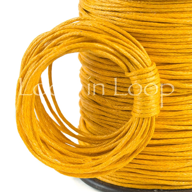 May include: A spool of vibrant yellow cord with a textured, twisted surface. A portion of the cord is looped and wrapped around the main spool, creating a circular shape. The text "Loop in Loop" is visible across the center of the yellow cord.