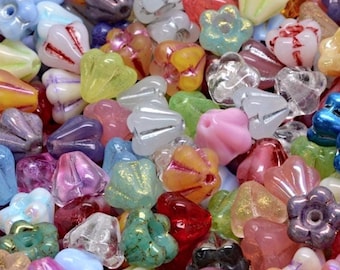 Peut inclure: Gros plan sur une collection de perles colorées de différentes formes, dont des fleurs et des gouttes. Les perles sont dans des tons de rose, bleu, vert, jaune et violet, certaines avec un éclat irisé. Ces perles sont idéales pour la fabrication de bijoux et l'artisanat.