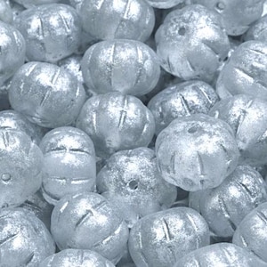 May include: A close-up of a pile of white, iridescent, round beads with a textured surface. The beads are made of glass and have a pearlescent finish.