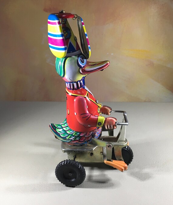 Collectibles Tin wind up toy duck on a bicycle with twirling helicopter