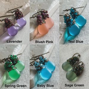 Pode incluir: Seis pares de brincos pendentes com contas de vidro fosco em forma de gota nas cores lavanda, rosa claro, azul-petr&oacute;leo, verde primavera, azul beb&ecirc; e verde s&aacute;lvia. Cada brinco possui uma se&ccedil;&atilde;o superior envolta em fio met&aacute;lico.