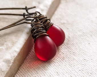Pendientes de cristal rojo rubí esmerilado en forma de lágrima, envueltos en alambre de latón envejecido.