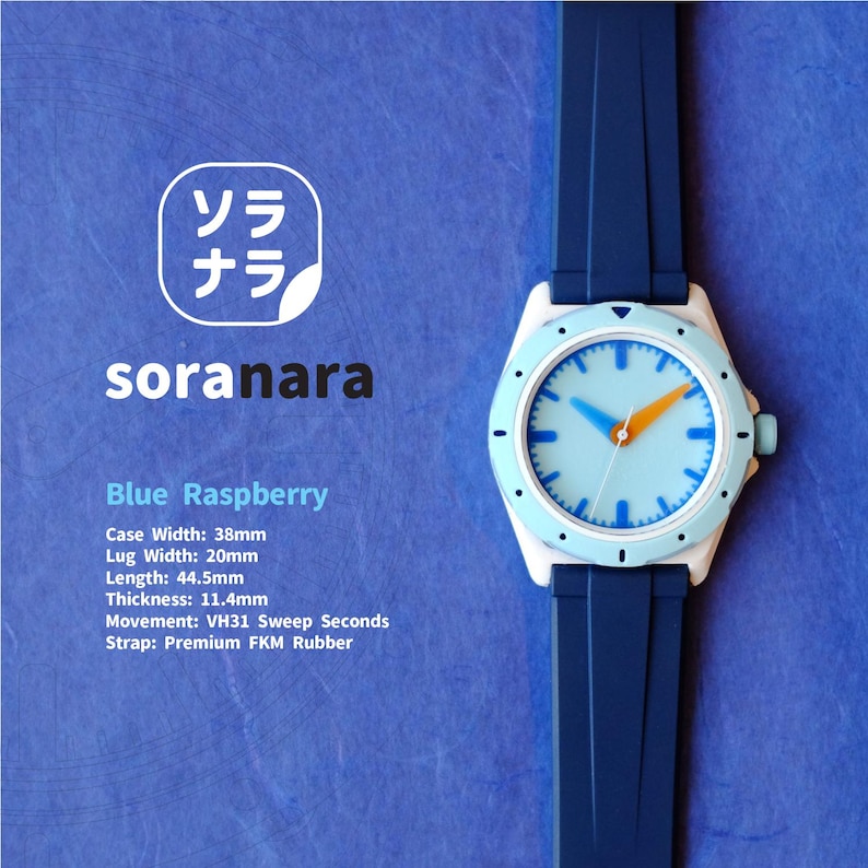 May include: A blue and white wristwatch with a blue rubber strap. The watch face is light blue with white markings and orange and blue hands. The watch is labeled "soranara" and "Blue Raspberry". The watch has the following specifications: Case Width: 38mm, Lug Width: 20mm, Length: 44.5mm, Thickness: 11.4mm, Movement: VH31 Sweep Seconds, Strap: Premium FKM Rubber.