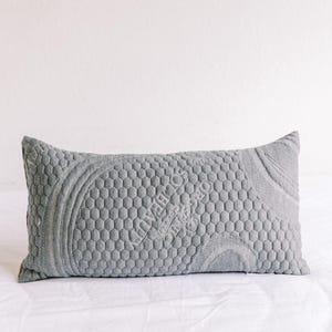 May include: A gray, rectangular pillow with a honeycomb pattern and the text "INVERLOCH" in white.