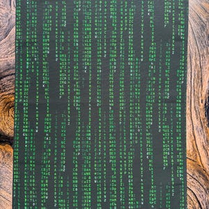 May include: A black and green fabric with a repeating pattern of letters and numbers. The letters and numbers are in a green font on a black background.