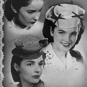 May include: Three women wearing different crocheted hats. The hats are all white and have a variety of designs. The women are all smiling and looking at the camera. The image is in black and white.