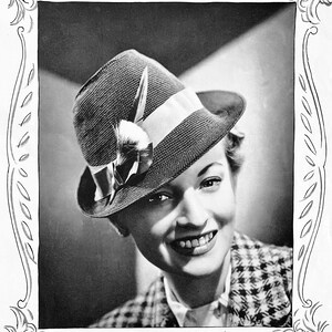 May include: A black and white photo of a woman wearing a black and white hat with a feather and a white ribbon. She is smiling and wearing a black and white checkered jacket.