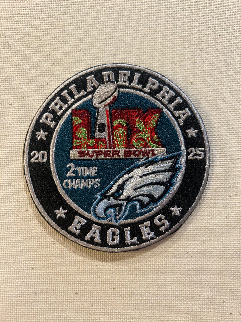 K&ouml;nnte beinhalten: Runder, gestickter Aufn&auml;her mit dem Logo und Text der Philadelphia Eagles. Der Aufn&auml;her hat einen t&uuml;rkis-schwarzen Rand. Er zeigt die Worte "Philadelphia Eagles", "Super Bowl" und "2 Time Champs". Der Aufn&auml;her zeigt auch die Super Bowl Troph&auml;e.