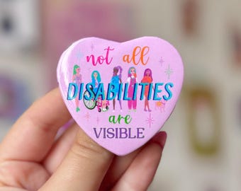 May include: Pink heart-shaped button with the text "not all disabilities are visible" and a colorful illustration of people with different disabilities.