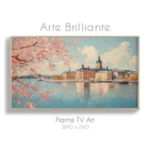 Könnte beinhalten: Ein gerahmter digitaler Kunstdruck mit dem Titel "Arte Brillante", der eine Stadtlandschaft mit Fluss, Gebäuden und rosa blühenden Bäumen zeigt. Das Kunstwerk befindet sich in einem rechteckigen Rahmen und ist mit "Frame TV Art 3840 x 2160" beschriftet.
