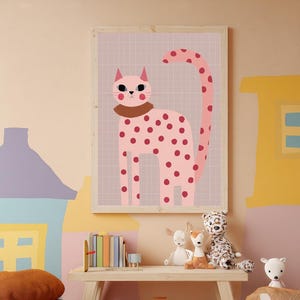 Può includere: Una stampa incorniciata raffigurante un gatto rosa a pois rossi con un collare marrone. L'opera d'arte è esposta nella cameretta di un bambino con una panca di legno, giocattoli e blocchi colorati.