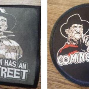 May include: Two black and white iron-on patches featuring Freddy Krueger from the movie A Nightmare on Elm Street. The first patch shows Freddy holding a glove with blades and the text "Every town has an Elm Street". The second patch shows Freddy holding a knife and the text "One, Two, Freddy's Coming For You".