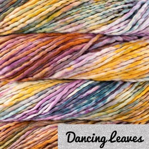 May include: Close-up of a skein of chunky yarn in a blend of colours. The yarn features shades of yellow, orange, purple, and teal. The text "Dancing Leaves" is visible in the bottom right corner.