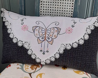 Mariposa vintage bordada a mano sobre almohada de lana