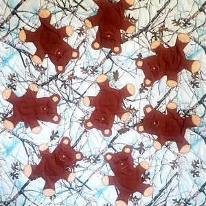 K&ouml;nnte beinhalten: Eine Steppdecke mit einem Tarnmuster, auf der braune Teddyb&auml;ren mit geschlossenen Augen zu sehen sind. Die B&auml;ren sind in verschiedenen Positionen &uuml;ber die Steppdecke verteilt.