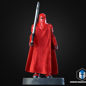 May include: A red Imperial Guard figure, standing on a gray base, holding a silver and black staff. The figure is wearing a red helmet and uniform with a long cape. The background is black. The figure is a collectible item.