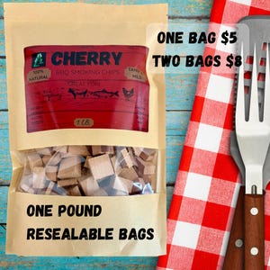 May include: A resealable bag of cherry BBQ smoking chips. The bag has a clear window showing wood pieces. The label is red with white text and includes the text "100% Natural" and "Great For". The bag is labeled "One Pound".