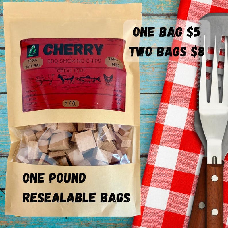 May include: A resealable bag of cherry BBQ smoking chips. The bag has a clear window showing wood pieces. The label is red with white text and includes the text "100% Natural" and "Great For". The bag is labeled "One Pound".