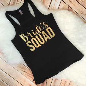 May include: Black tank top with gold lettering that says "Bride's Squad".