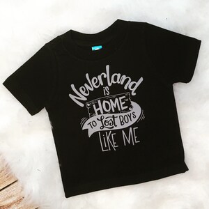 May include: Black t-shirt with a white graphic that says "Neverland is home to lost boys like me".