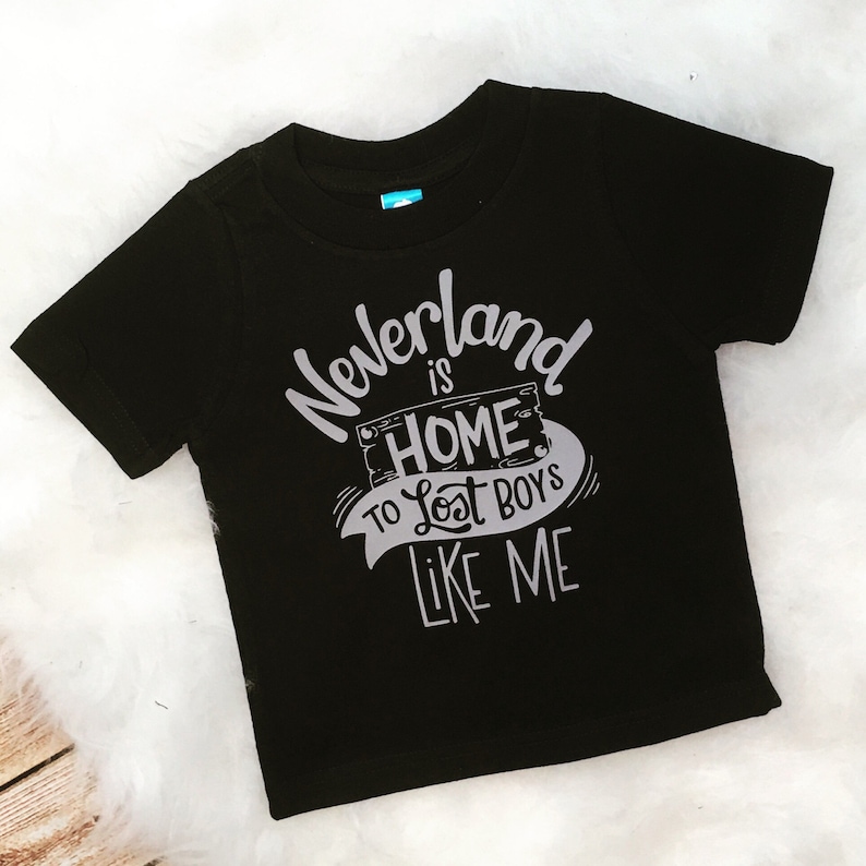 May include: Black t-shirt with a white graphic that says "Neverland is home to lost boys like me".